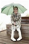 Older woman sitting under umbrella