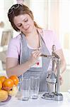Woman squeezing orange juice in kitchen