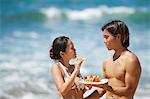 Couple eating together on beach