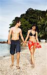 Smiling couple walking together on beach