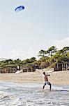 Man flying kite on beach