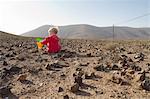 Toddler playing with buckets in desert