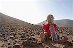 Toddler with bottle of water in desert