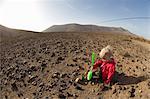 Toddler playing with shovel in desert