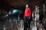 Hiker with stalactites in glacial cave