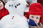 Close up of boy hugging snowman