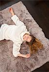 Smiling woman laying on rug