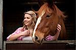 Teenage girl with horse in stables