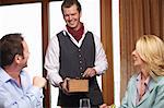 Waiter serving business people in cafe