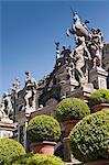 Shrubs with ornate statues and columns