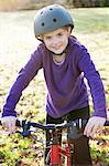 Girl riding bicycle in meadow