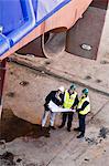 Workers reading blueprints at dry dock