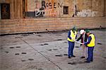 Workers reading blueprints on dry dock