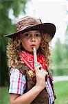 Girl in cowboy hat with toy pistol