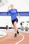 Woman running on indoor track in gym