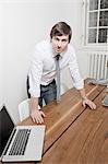 Businessman leaning over desk