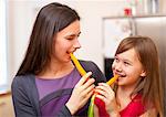 Mother and daughter eating carrots