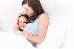 Mother and daughter relaxing in bed