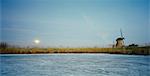 Rural windmill on frozen river