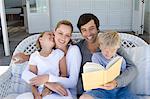 Family reading on sofa together