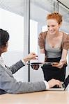 Businesswoman offering cup of coffee