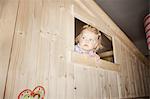 Girl peeking out window of playhouse