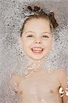 Smiling girl laying in bubble bath