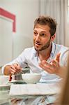 Smiling man talking at breakfast