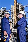 Workers talking at oil refinery