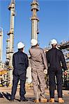 Workers standing at oil refinery