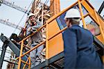 Workers talking at oil refinery