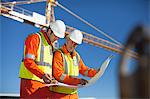 Workers reading blueprints on site