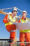 Workers reading blueprints on site