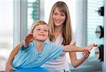 Trainer working with boy in gym