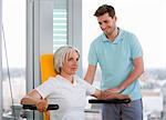 Trainer working with woman in gym