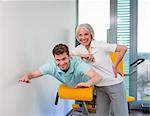 Trainer working with man in gym