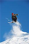 Skier jumping off snowy slope