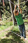 Boy playing on tightrope outdoors