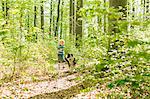 Boy walking with dog in forest