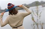 Woman playing with knitted hat outdoors