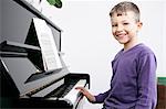 Smiling boy practicing at piano