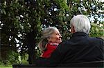 Older couple sitting on park bench