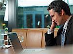 Businessman working on laptop in cafe