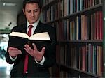 Businessman reading book in library