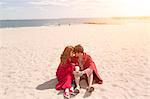 Romantic couple wrapped in blankets at beach