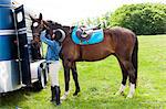 Horse rider putting on horse's bridle