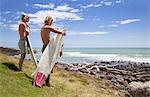 Two young male surfer friends watching sea
