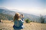 Rear view of mid adult woman photographing view on smartphone, Lake Arrowhead, California, USA