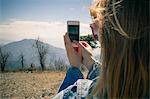 Cropped shot of mid adult woman photographing view on smartphone, Lake Arrowhead, California, USA