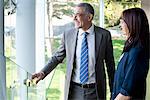 Businessman and woman looking out of office building